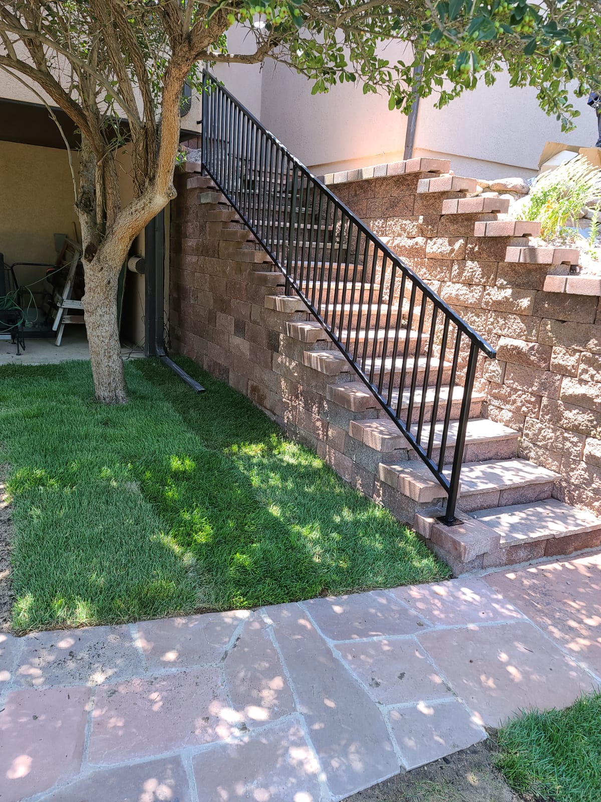 Completed staircase with iron railing and stone patio